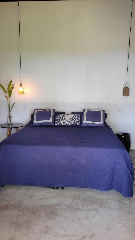 a large purple bed in a white room at Karabebae bungalows Remo in Marau