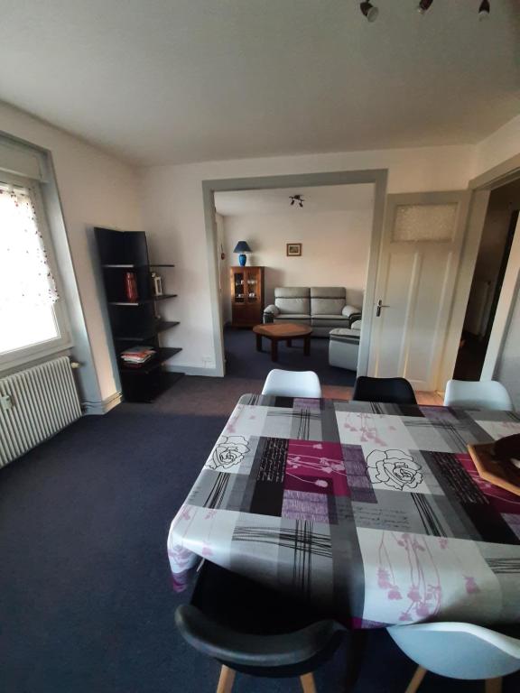 une pièce avec une table, des chaises et un canapé dans l'établissement F6 2e étage 4 chambres Gerardmer Centre, à Gérardmer