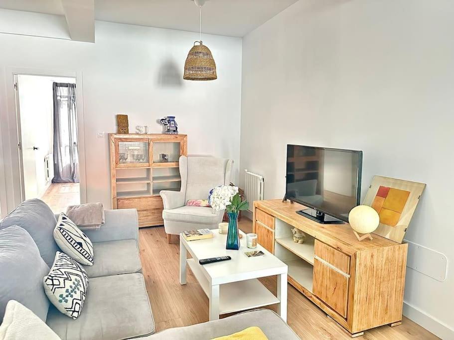 Una sala de estar con un sofá y un televisor. en Olivo, en Ferrol