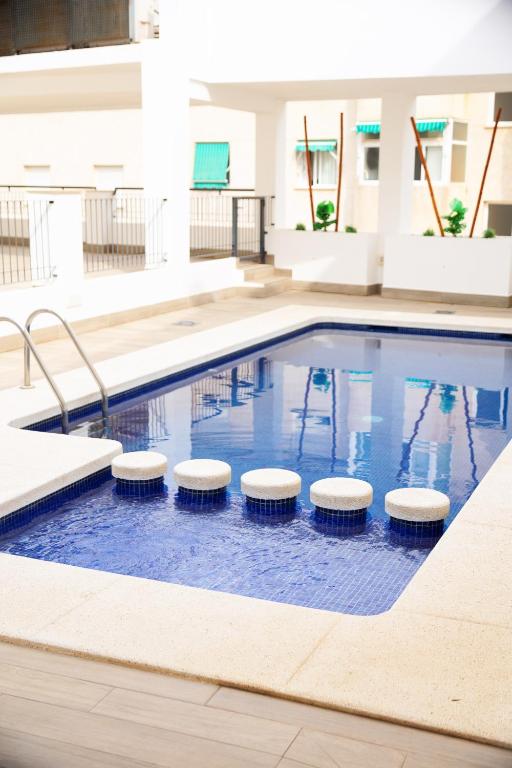 a swimming pool with stools in a building at El Toro Apartments in Altea