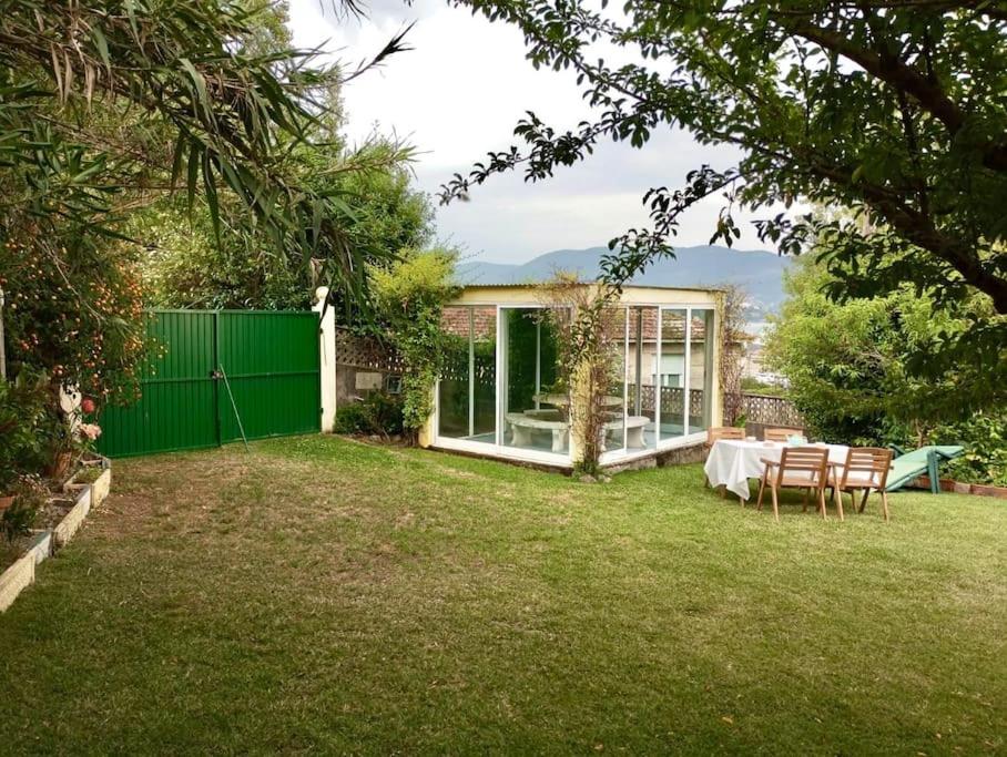 una casa con una valla verde y una mesa en un patio en As Barrocas, en Nigrán