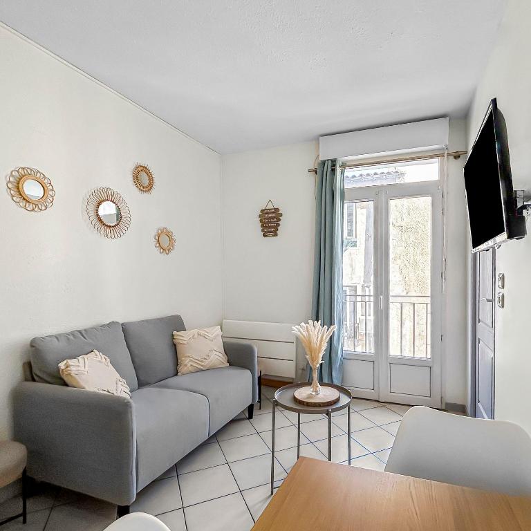 un salon avec un canapé et une télévision dans l'établissement Cosy et Fonctionnel - Proche Canal & Parc, à Sète