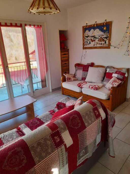 un salon avec un lit et un canapé dans l'établissement Appart 4 chambres - Centre Lélex, à Lélex