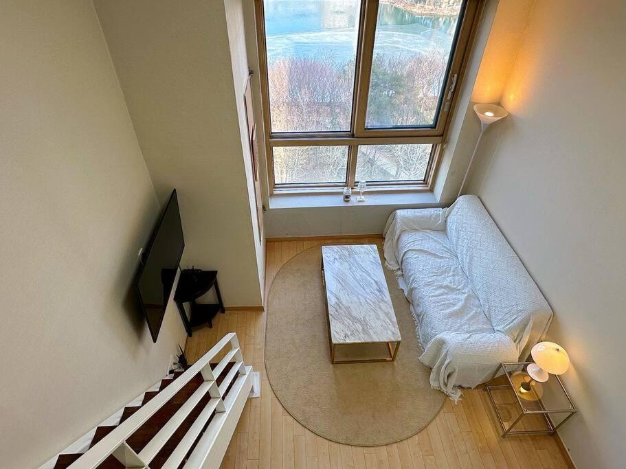 una sala de estar con un sofá y una mesa en Comfortable Duplex House with City Lake View #SeokchonLakeView #LotteWorld, en Seúl