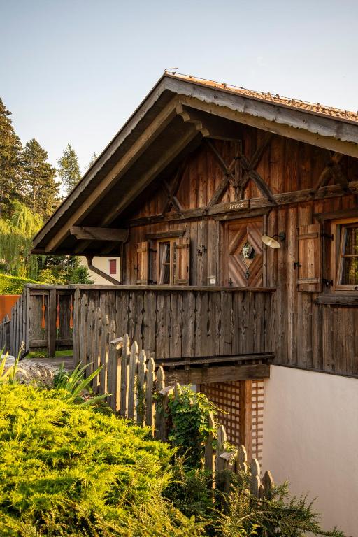 drewniany dom z płotem przed nim w obiekcie Pineta Natural Chalet w mieście Coredo