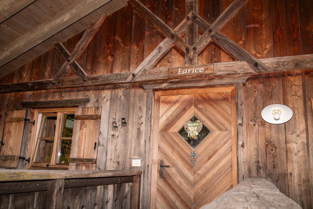 drewniany budynek z drzwiami i oknem w obiekcie Pineta Natural Chalet w mieście Coredo