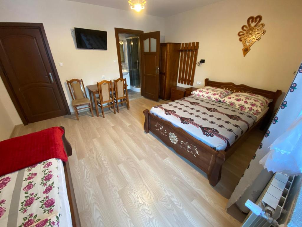 a bedroom with a bed and a table and chairs at Domek pod lasem in Białka Tatrzanska