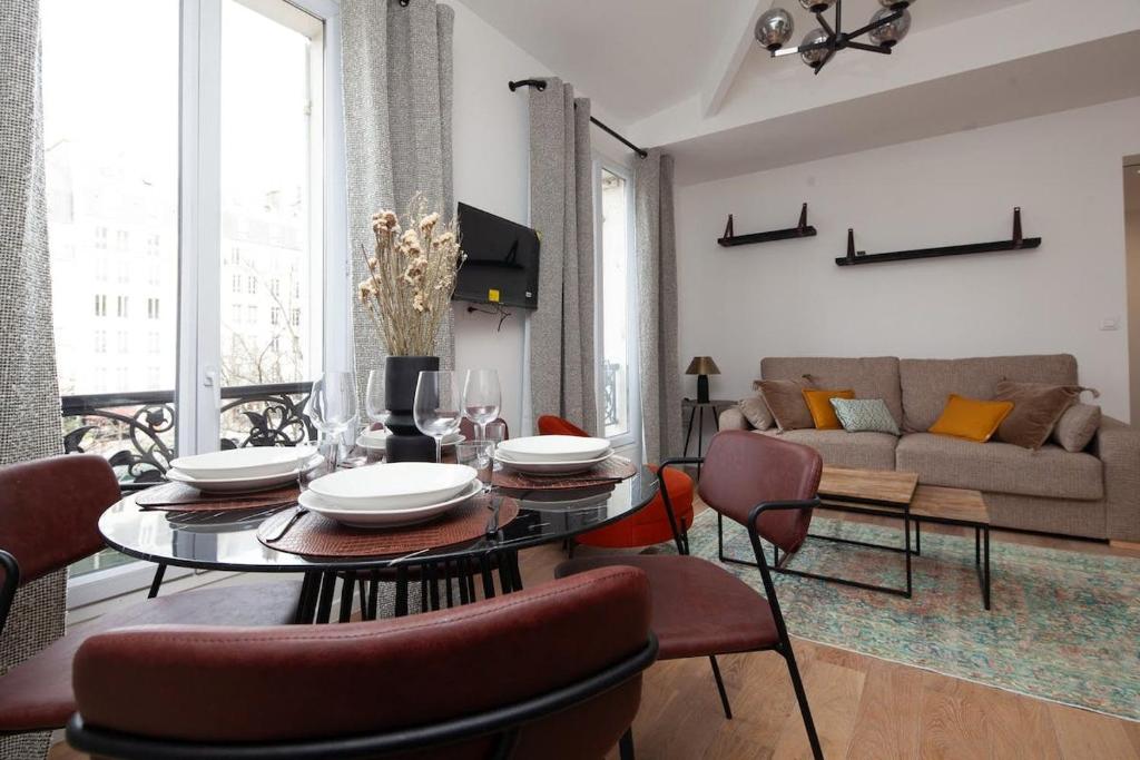 un salon avec une table, des chaises et un canapé dans l'établissement Paris 15 - Tour Montparnasse - Bd Pasteur - 2 pièces, à Paris