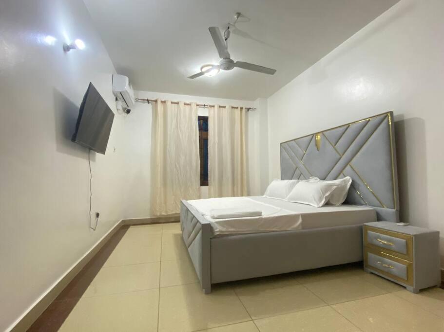 a bedroom with a bed and a flat screen tv at Ocean view homes in Mombasa
