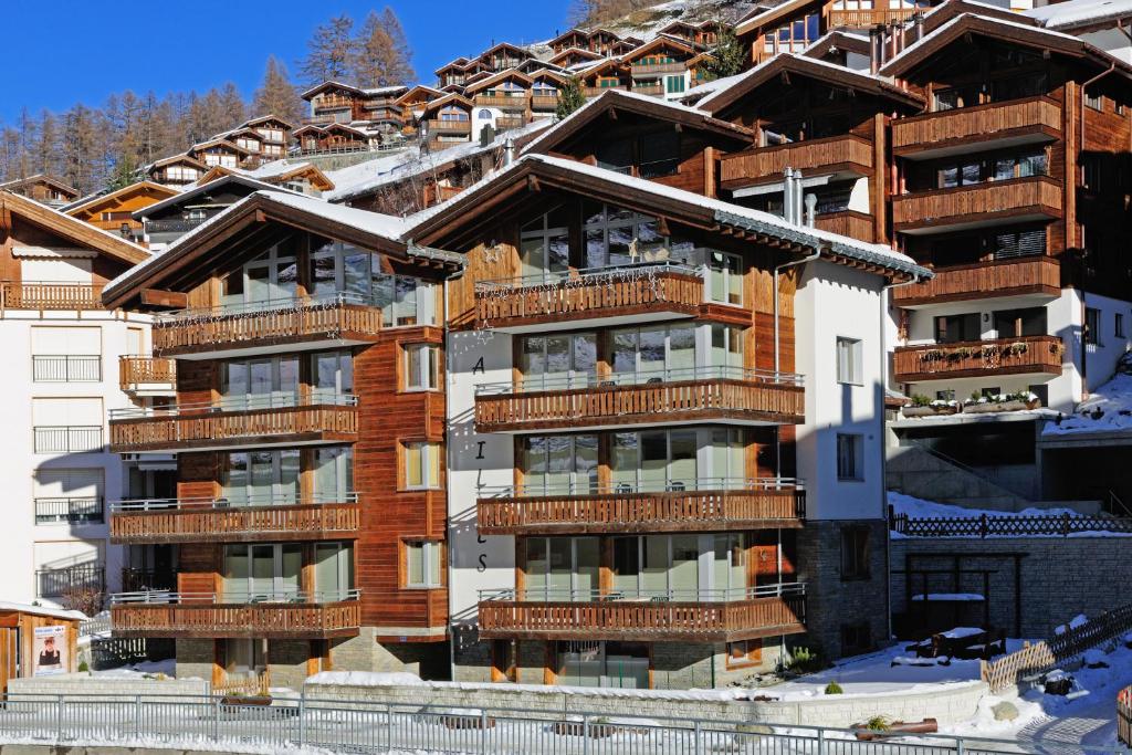 ein Apartmenthaus mit Balkon im Schnee in der Unterkunft Ferienwohnung Haus Achilles in Zermatt