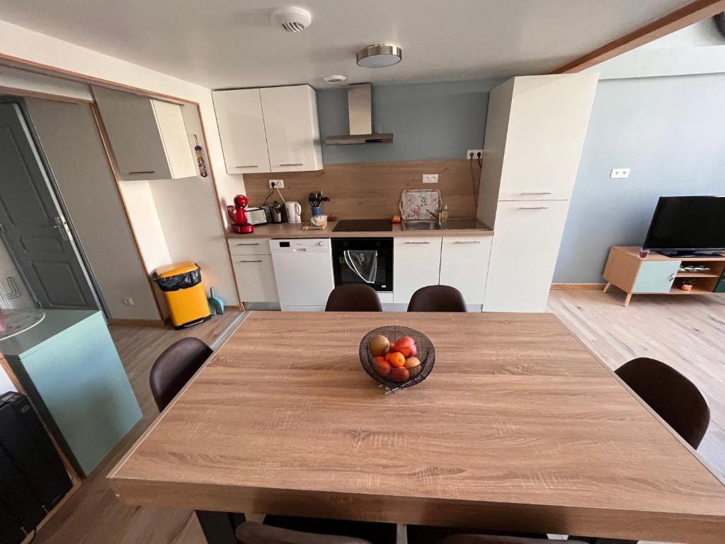 - un bol de fruits sur une table en bois dans la cuisine dans l'établissement Duplex La Bourboule, à La Bourboule