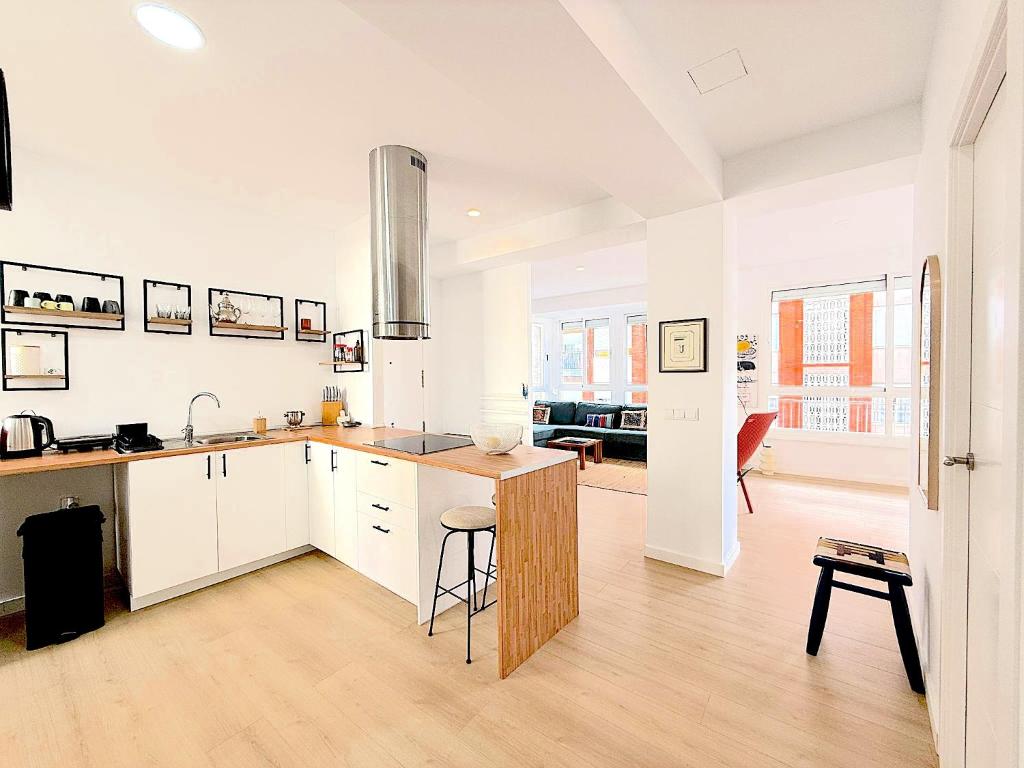 a kitchen with white cabinets and a sink and a table at Casa Blanca sea view in Santa Pola