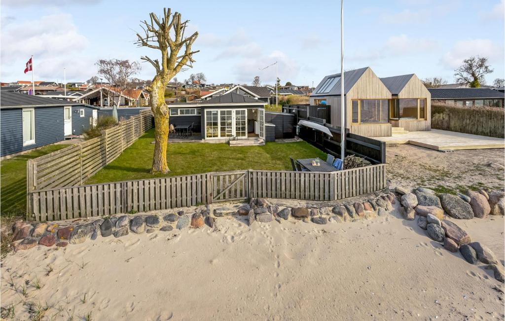 RøndeにあるLovely Home In Rønde With Kitchenの塀と木のある海辺の家
