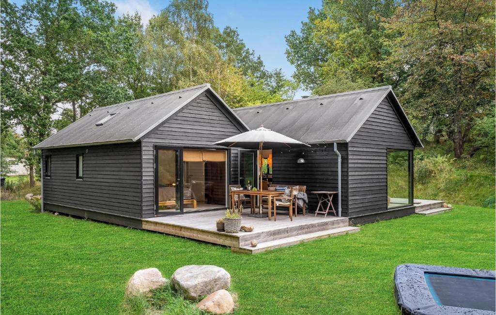 un hangar noir avec une table et un parasol dans l'établissement Stunning Home In Fårevejle With Kitchen, à Fårevejle