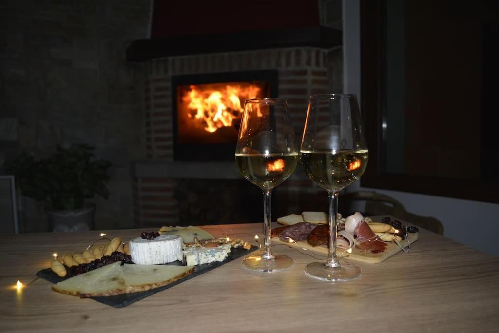 two glasses of wine sitting on a table with food at Casa La Peguera in La Parra