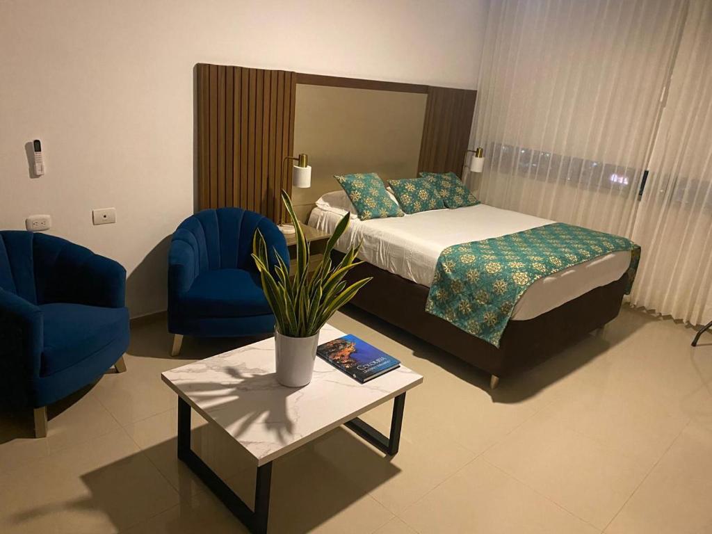 a hotel room with a bed and a table and chairs at Apartamento Hotel Estelar Alto prado Junior Suite in Barranquilla