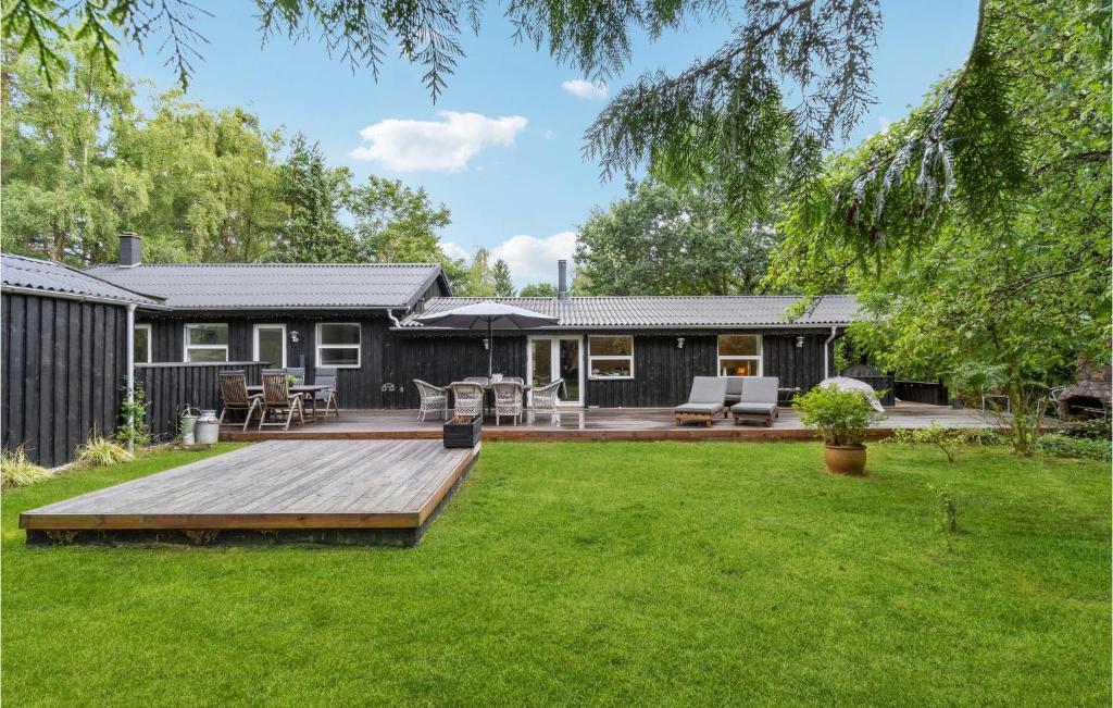 a backyard with a wooden deck and a house at 3 Bedroom Pet Friendly Home In Græsted in Græsted