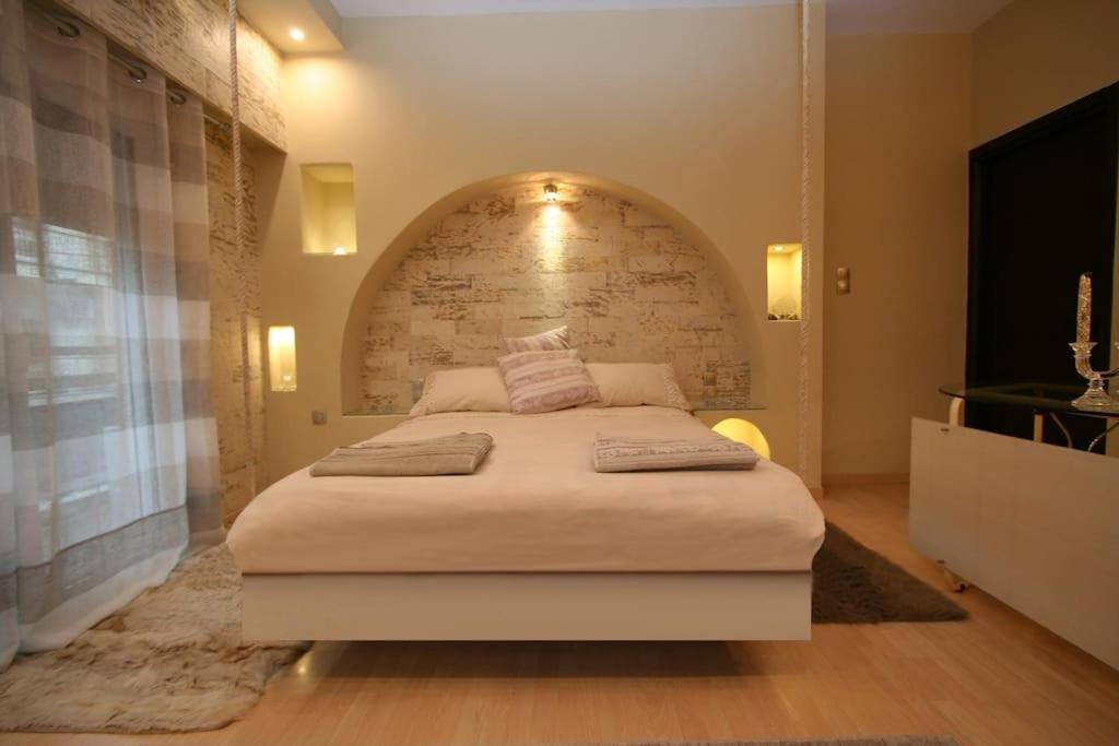 a bedroom with a large bed with a brick wall at C i t y v i b e s Διαμέρισμα Α1 in Ioannina