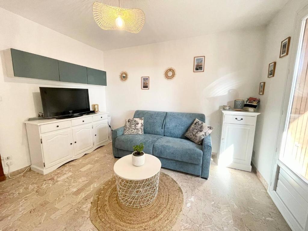 un salon avec un canapé bleu et une table dans l'établissement Studio Portissol, à Sanary-sur-Mer