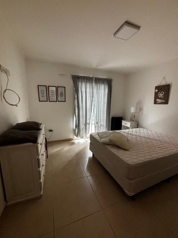 a bedroom with a large bed and a window at Departamento en planta baja in Necochea