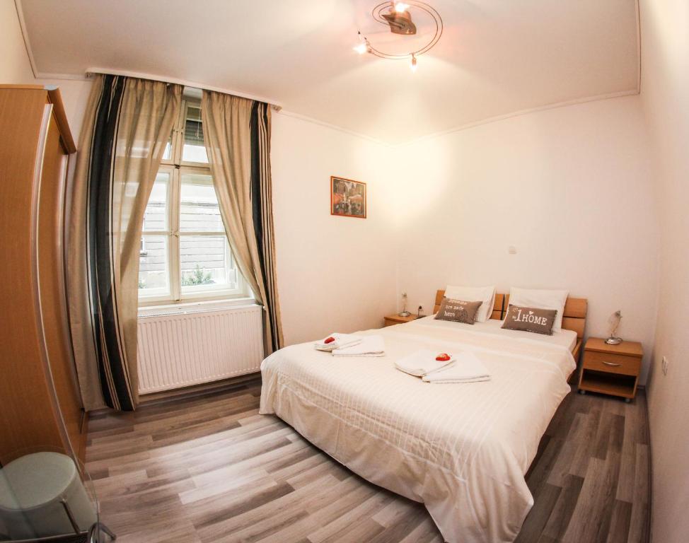 sypialnia z dużym białym łóżkiem i oknem w obiekcie Rooms Eliza w Zagrzebiu
