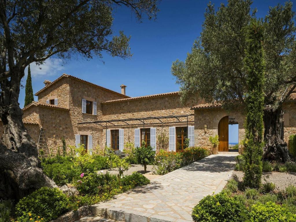 an exterior view of a stone house with trees at Holiday home with spacious lounge area in Banyalbufar