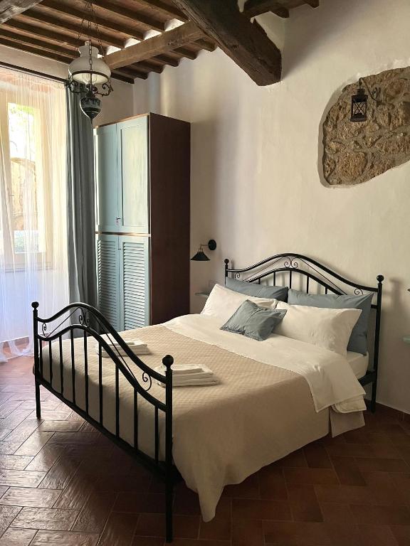 a bedroom with a large bed with white sheets at Il Girasole Storico in Pitigliano