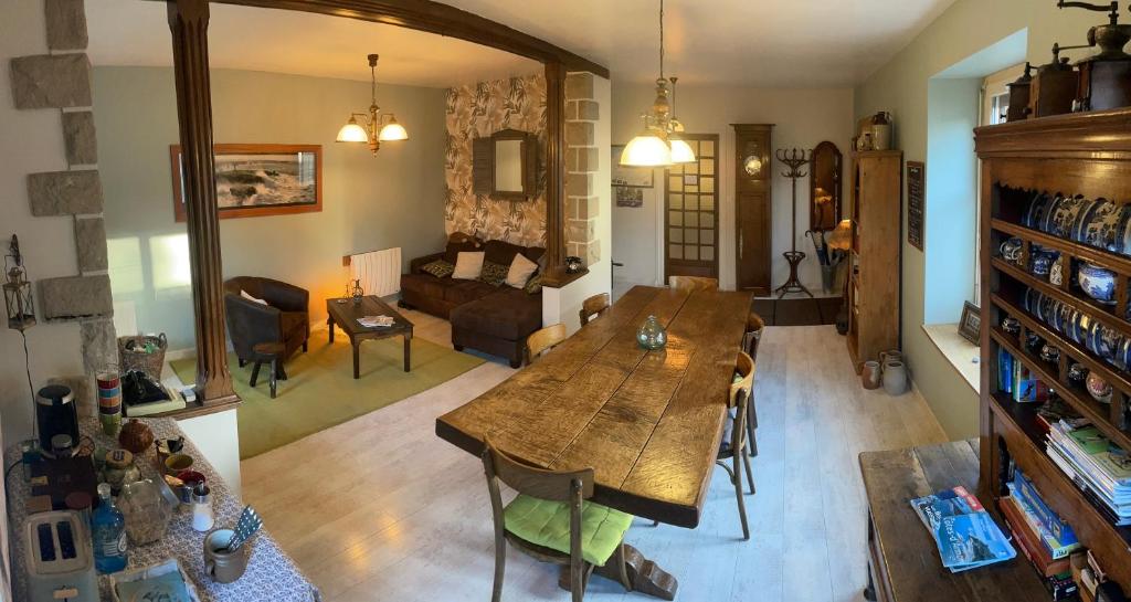 a living room with a table and a couch at Les Petits Gallais in Saint-Carreuc