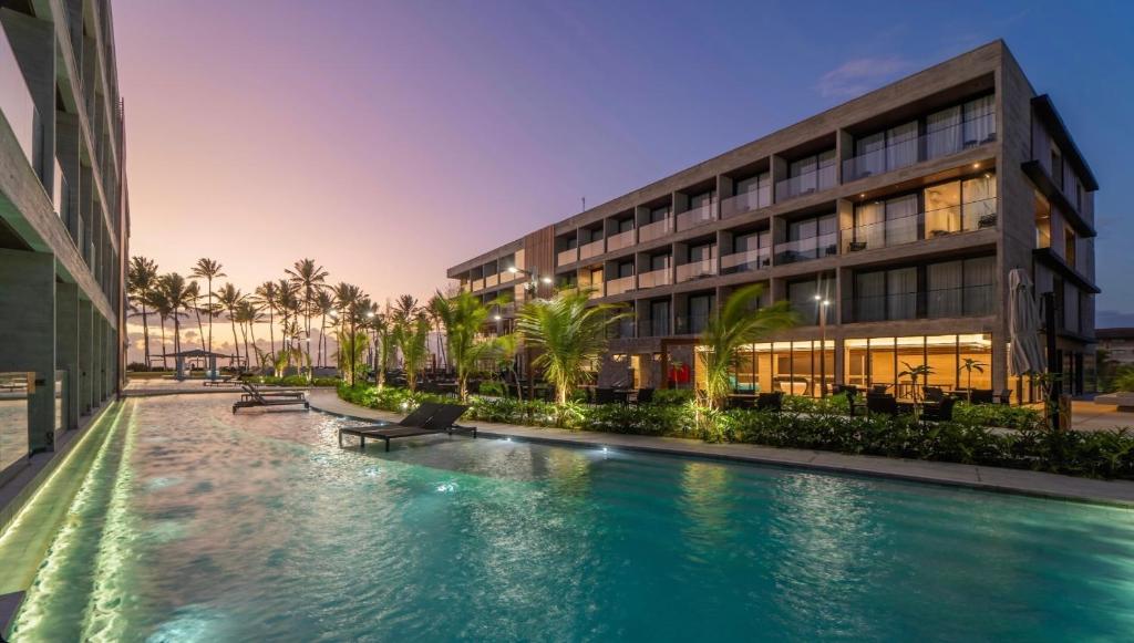 a hotel with a swimming pool in front of a building at Meu Resort Porto Alto in Cupe