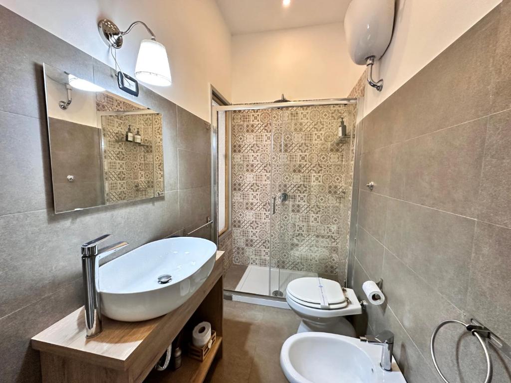 un bagno con lavandino, WC e specchio di Welcome to I Colori di Napoli a Napoli