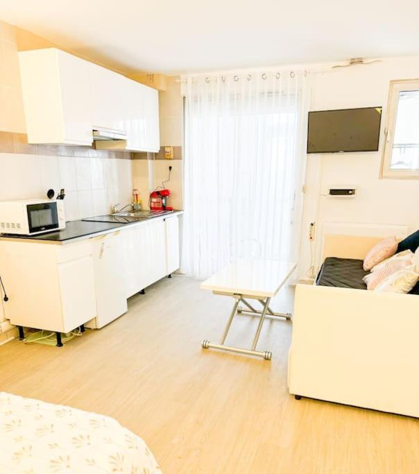 - une cuisine blanche avec un canapé et une table dans l'établissement Appartement front de mer, à Canet