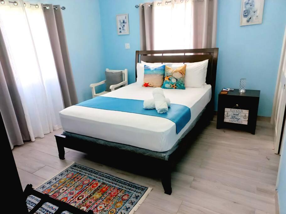 a bedroom with a large bed with blue walls at BlissVacay Couples or Singles Tropical Vacay Retreat in Creekside
