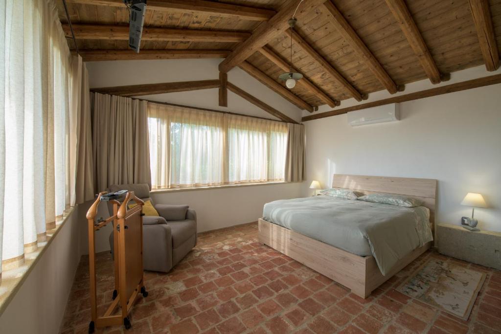 a bedroom with a bed and a couch and a chair at Tenuta Cascina Marenco in Gavi
