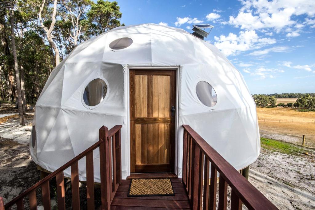 a round house with a wooden door and a porch at Mile End Glamping Pty Ltd in Yelverton