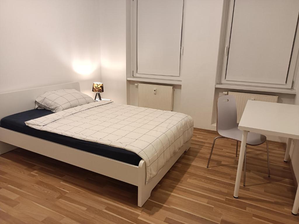 a bedroom with a bed and a table and a desk at Komfortable Wohnung in Kassel