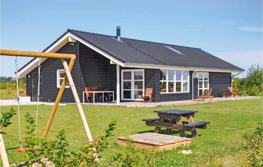 a small house with a picnic table and a swing at Holiday Home Pilemose in Skovby