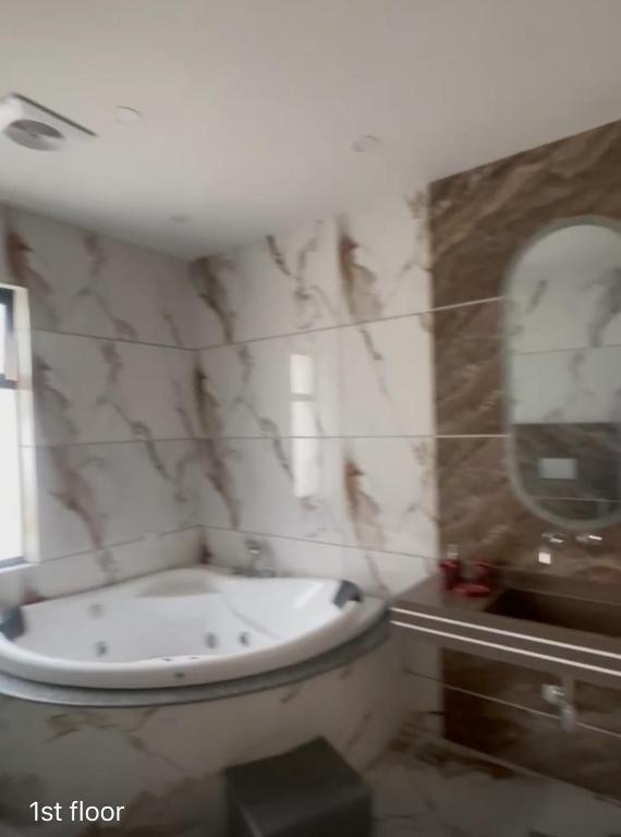 a bathroom with a white toilet and a mirror at Destiny Villa in Rawalpindi