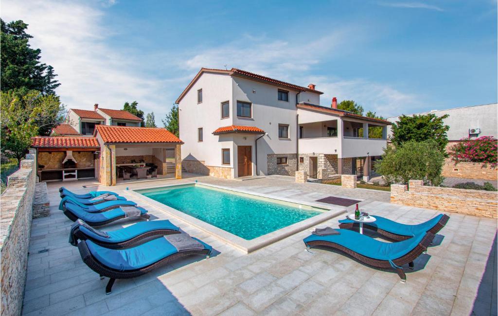 a villa with a swimming pool and a house at Holiday Home Premantura With Fireplace Iv in Premantura