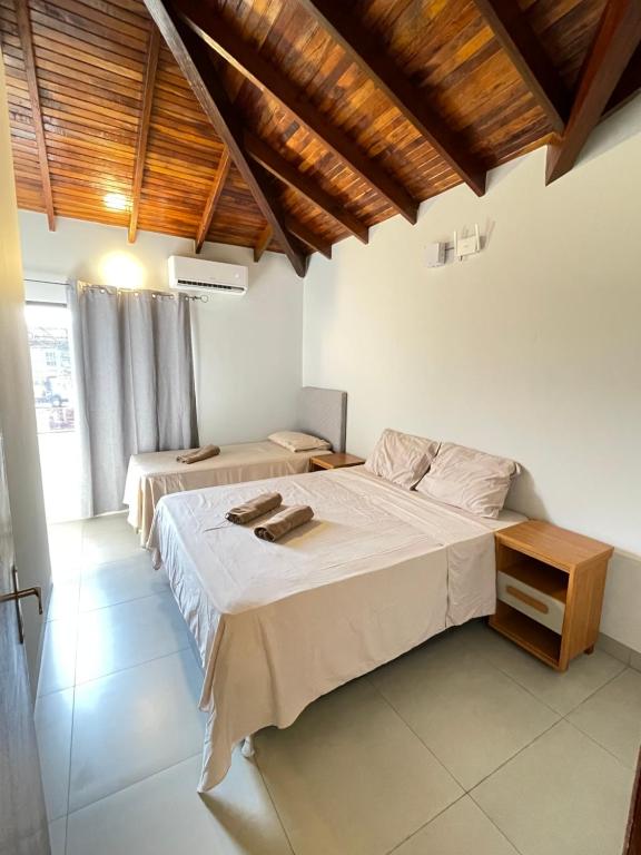 Dos camas en una habitación con techos de madera. en CDE duplex Rent II - 2 Dormitorios - 4 camas, en Ciudad del Este
