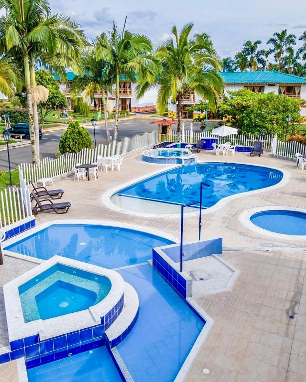 a resort with two pools and palm trees at Hotel La Aldea Pijao in Montenegro