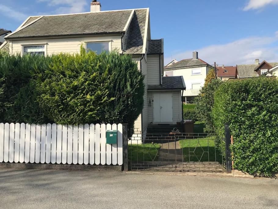 a white fence in front of a white house at Independent Apartment in Sandnes in Sandnes