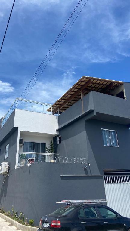a house with a car parked in front of it at Casa temporada Cabo Frio Casa pôr do Sol in Cabo Frio