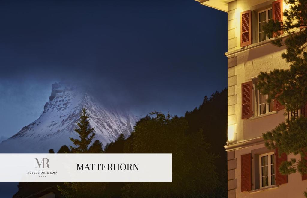 
a tall building with a clock on it at Monte Rosa Boutique Hotel in Zermatt
