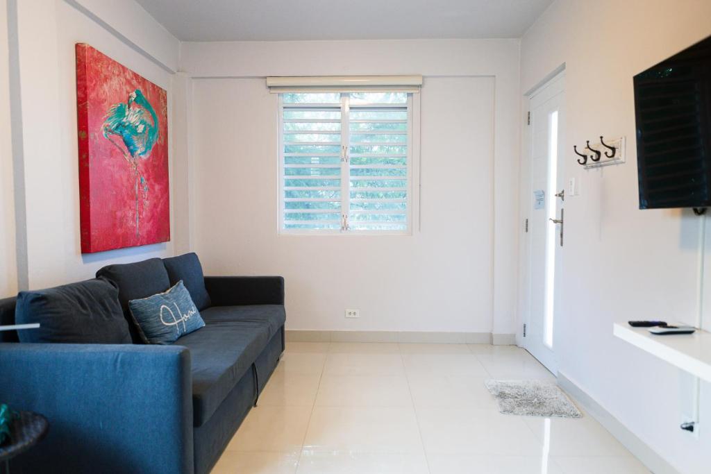 a living room with a blue couch and a window at 103-Delightful GEM in the city, Close to the Beach with Free Parking in San Juan