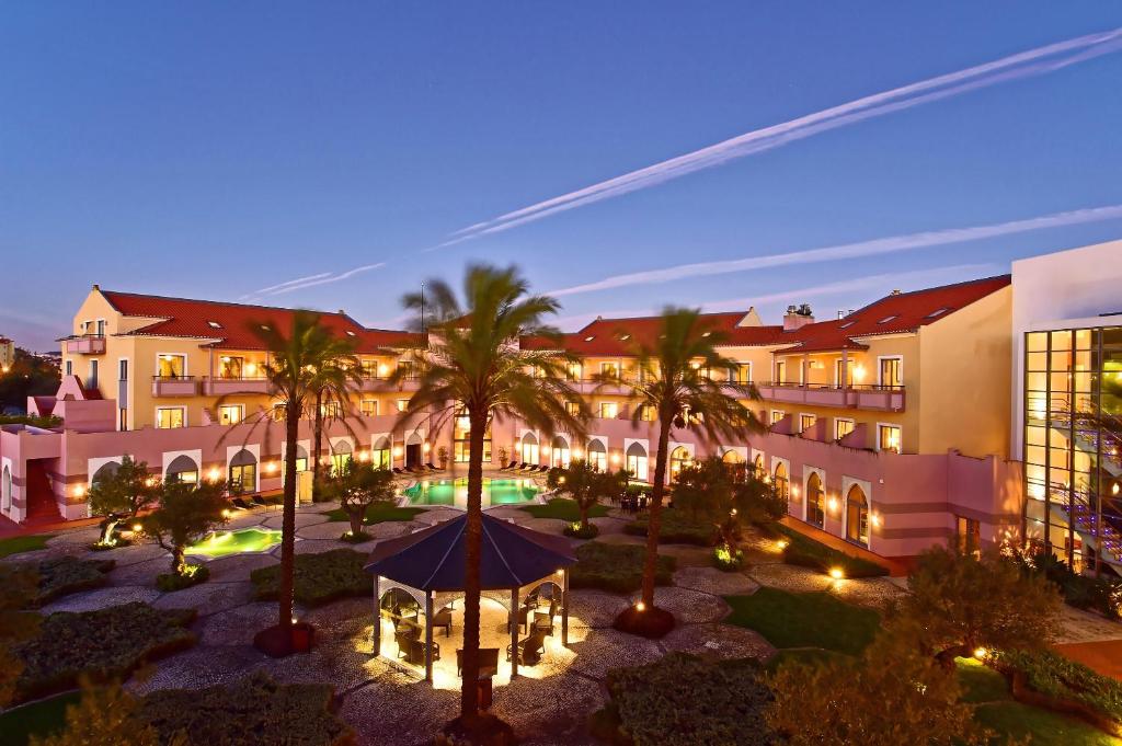 un hotel con un patio con cenador y palmeras en Pestana Sintra Golf Resort & SPA Hotel en Sintra