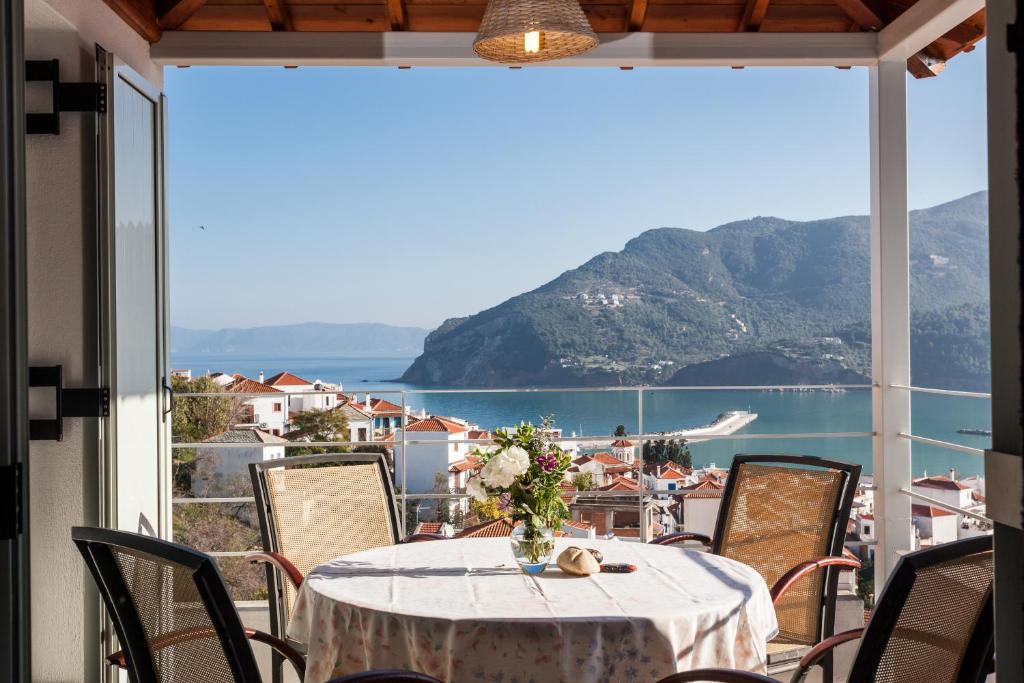 a table on a balcony with a view of the ocean at Thea Home Hotel in Skopelos Town