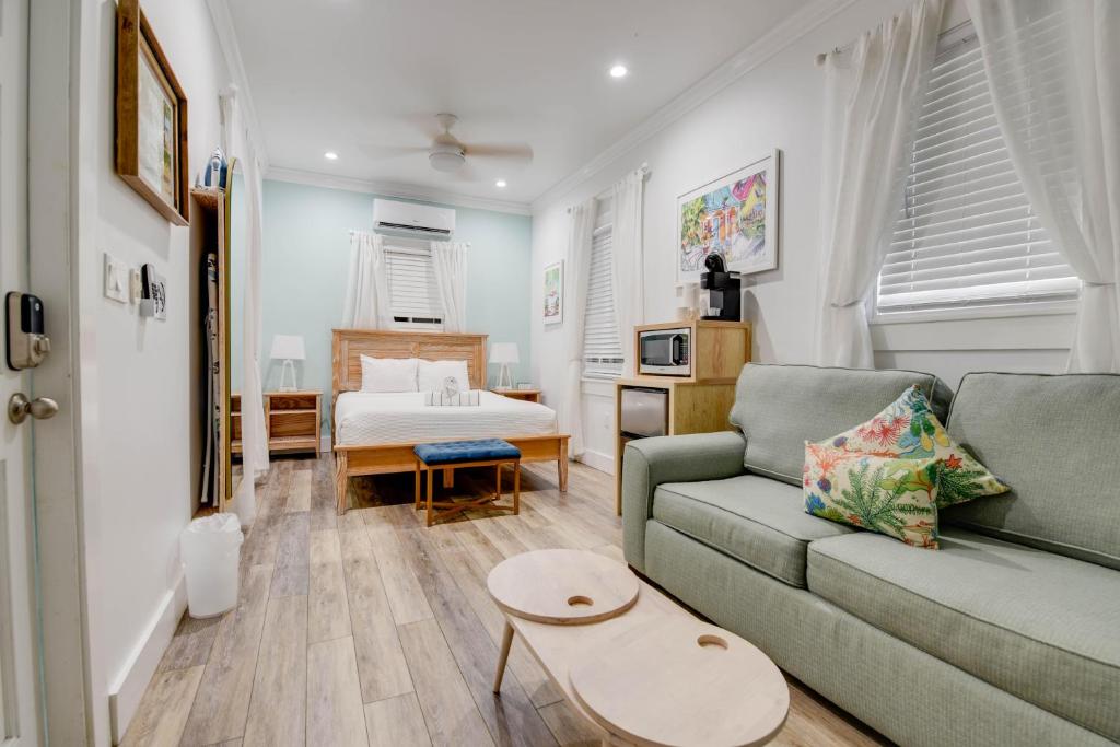 a living room with a couch and a bed at Pilar Cottage - Harbor Walk Hideaways in Key West