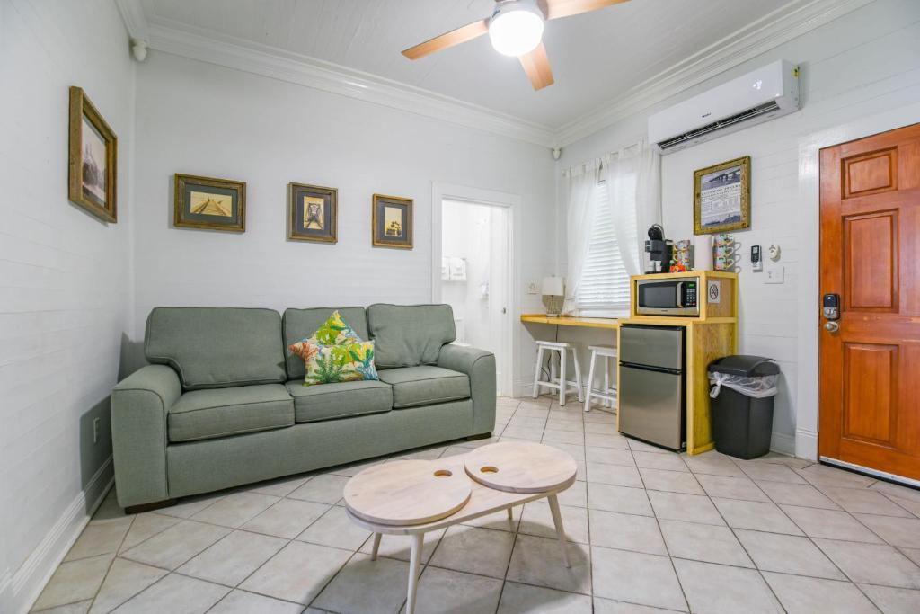 een woonkamer met een bank en een tafel bij Atocha Cottage - Harbor Walk Hideaways in Key West