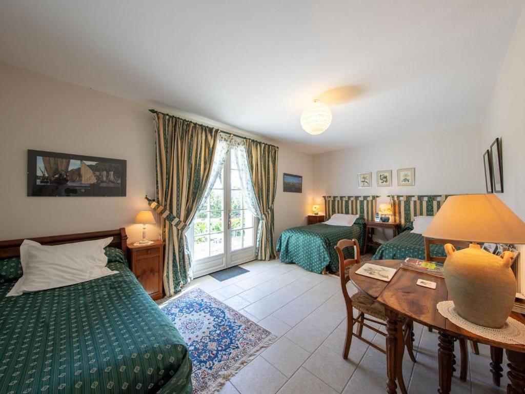 a hotel room with two beds and a table and a table sidx sidx at Chambre La Loire - Accès Handicapé, WiFi, Animaux admis - FR-1-590-458 in Saint-Benoît-sur-Loire