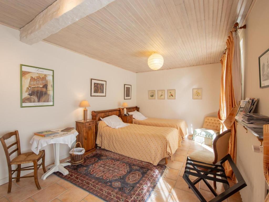 a bedroom with a bed and a table and chairs at Chambres et Suites au Calme avec Wifi et Animaux Acceptés - FR-1-590-475 in Saint-Benoît-sur-Loire